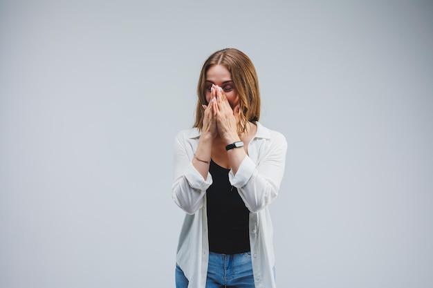 灰色の背景に白衣を着た現代の陽気な医者彼女の顔に笑顔の女性医師