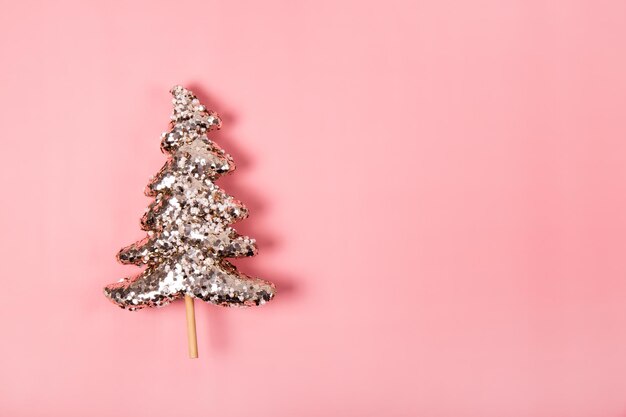 Modern christmas background with golden christmas tree on a pink background copy space for text