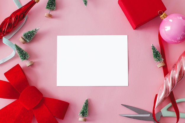 Modern Christmas card mockup Empty card with space for text and decorations on pink flat lay