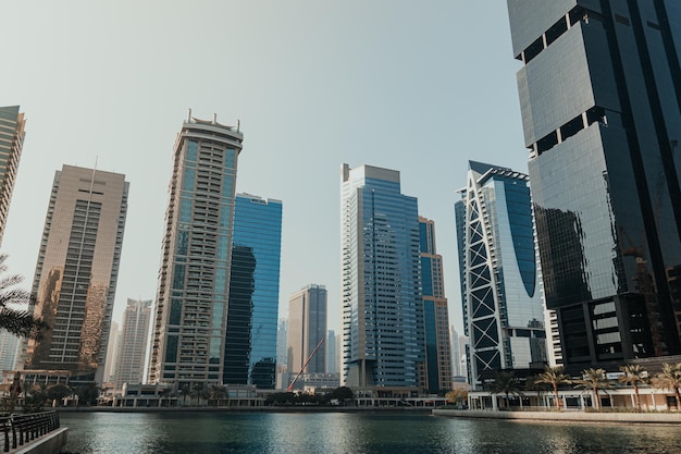 Modern city skyscrapers buildings at sunset time with business and residential towers around a lake