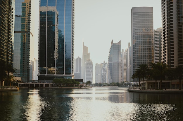 Modern city skyscrapers buildings at sunset time with business and residential towers around a lake