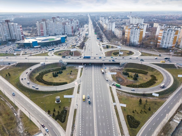 Modern city with the road in the form of a quatrefoil on the road junction of Odessa square around background of a cloudy sky autumn day. Aerial view from the drone. Kiev, Ukraine