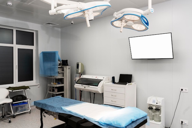 Photo modern clinic and operating room operating table in the ward blank screen on the wall copy space place for text