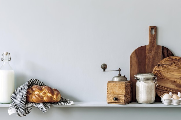 Modern composition on the kitchen interior with vegetables cutting board food herbs kitchen accessories and copy space on the shelf