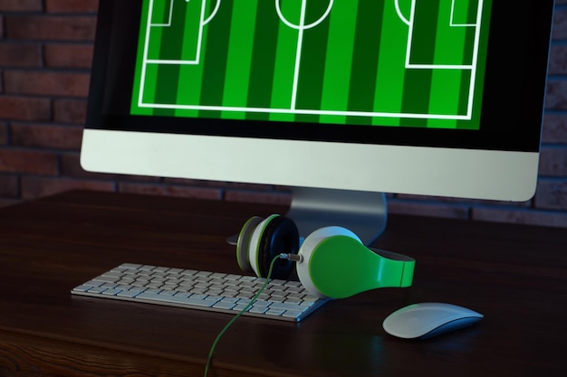 Modern computer and headphones on table in dark room Playing video games