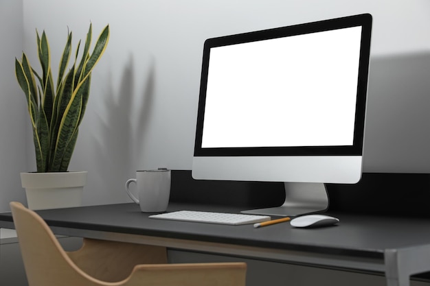 Modern computer with blank screen on black table indoors Mockup for design