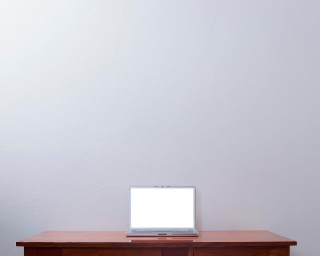 사진 테이블과 벽 배경에 빈 화면을 가진 현대 컴퓨터 노트북 작업장 모 개념