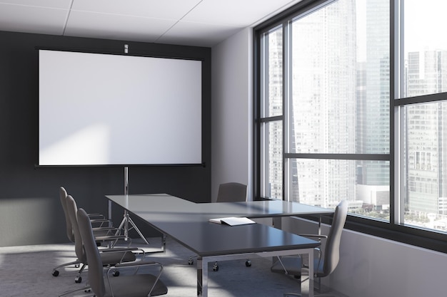 Modern conference room interior with a concrete floor, white and black walls and a long gray table with chairs. A blank screen. 3d rendering mock up