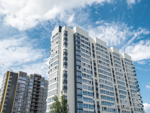 Modern construction new neighborhood Beautiful new buildings Colored wall on the background of blue cloudy sky Copy space