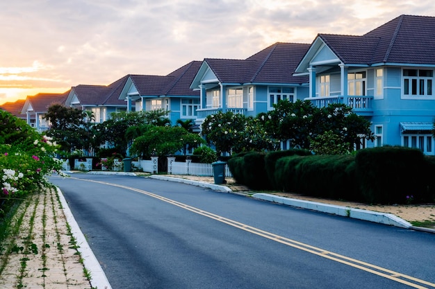 Modern cottages row road sidewalk two story buildings residential villas village New Estate Reflection dawn Sun in windows