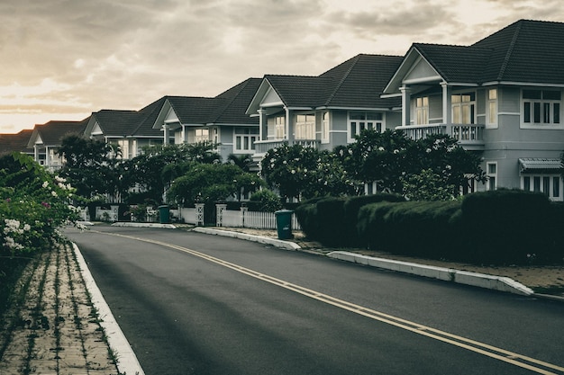 Modern cottages row road sidewalk two story buildings residential villas village New Estate Reflection dawn Sun in windows