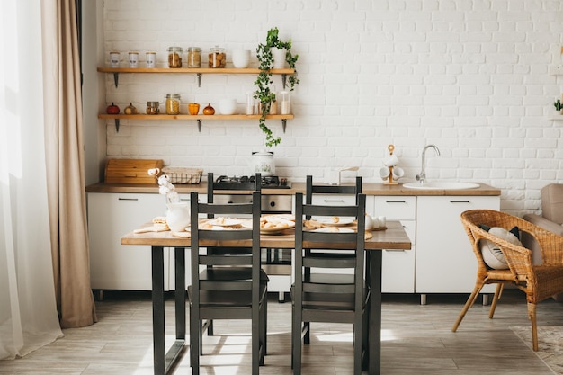 Modern cozy white kitchen interior with dining tablefurniture\
advertisementrenovation service concept