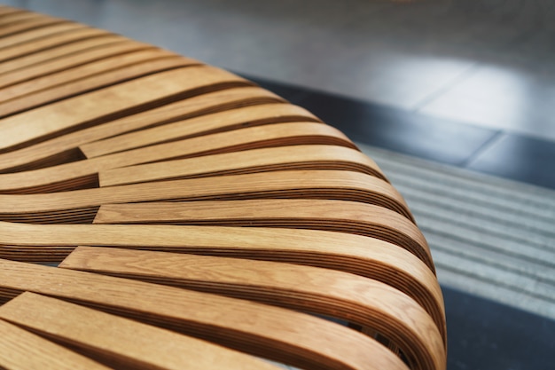 空港のモダンな湾曲した木製のベンチ。モダンなインテリアのクローズアップ