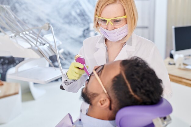 Foto dentista moderno che tratta paziente