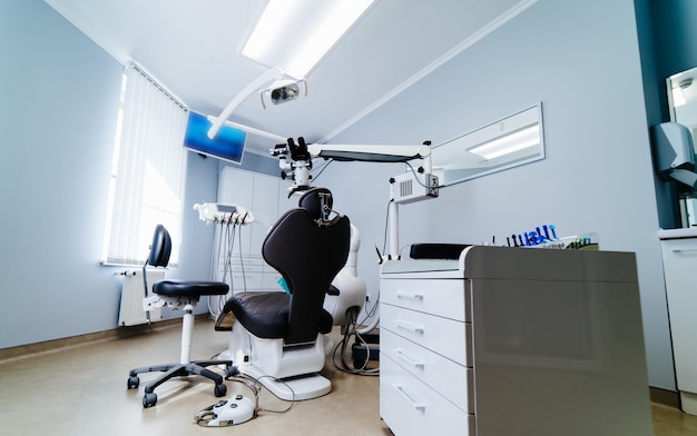 의자와 도구가 있는 현대 치과 사무실 인테리어 구강학의 현미경