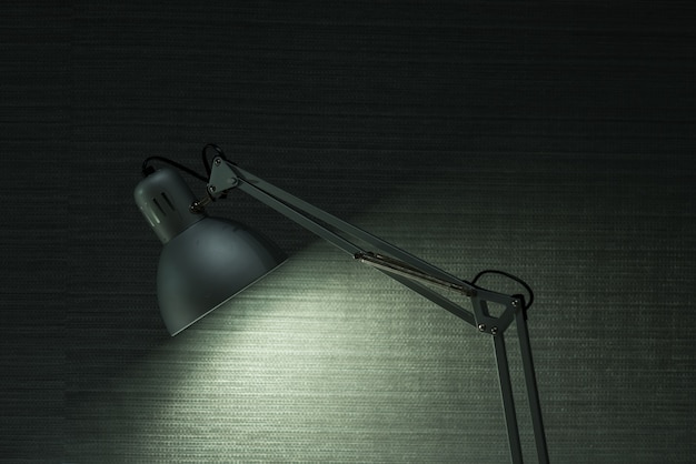 The modern desk lamp illuminate on the wall background.