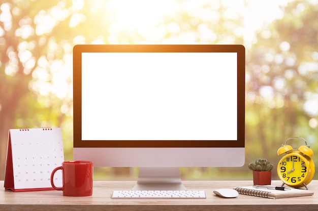 Modern desktop computer, Coffee cup, alarm clock, notebook and calendar 