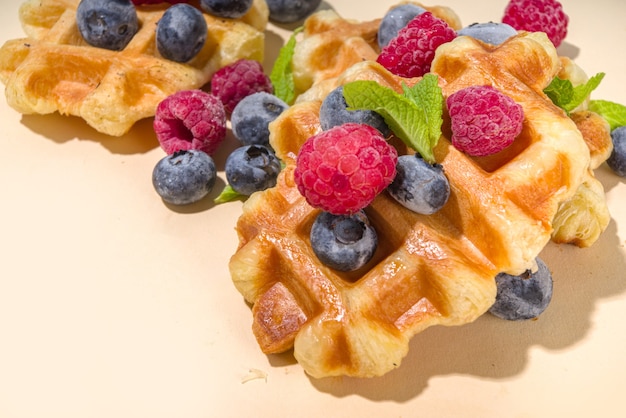 Modern dessert croffle - mixture of croissants and waffles, puff baking waffle iron pan, with berry, fruit cocolate topping