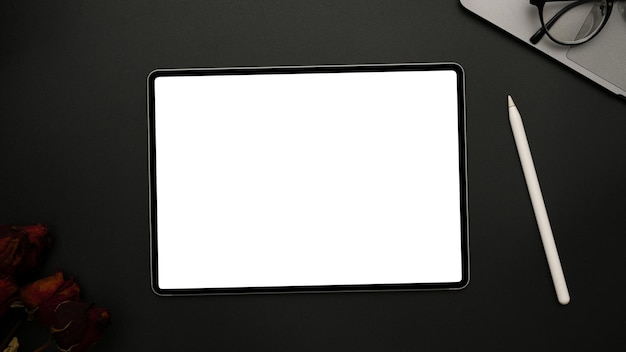 Modern digital tablet white screen mockup on black background with accessories top view