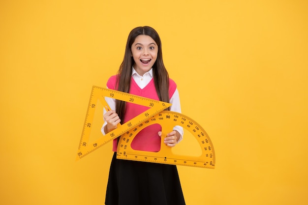 Modern education concept concept of education measure the angle child with triangle amazed teen girl hold protractor ruler back to school algebra and geometry kid study math stem disciplines