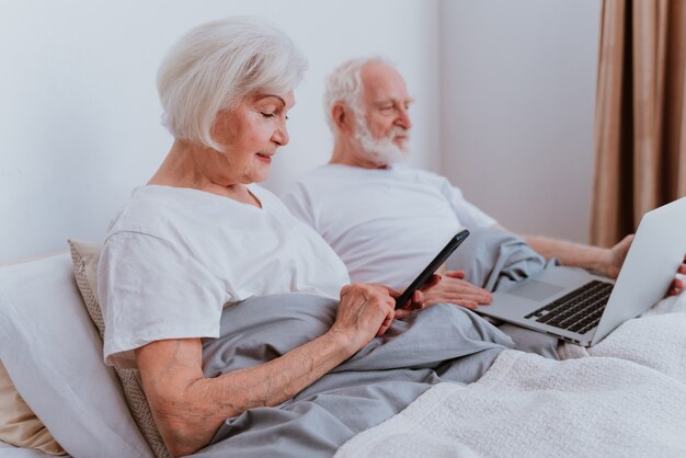 Modern elderly couple surfing the internet on laptop computer