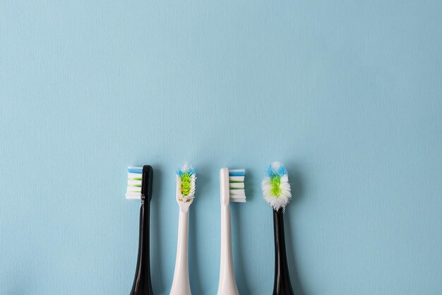 Modern electric toothbrush on a blue background it's time to change the brush old and new brush attachment Hygiene concept for daily oral care