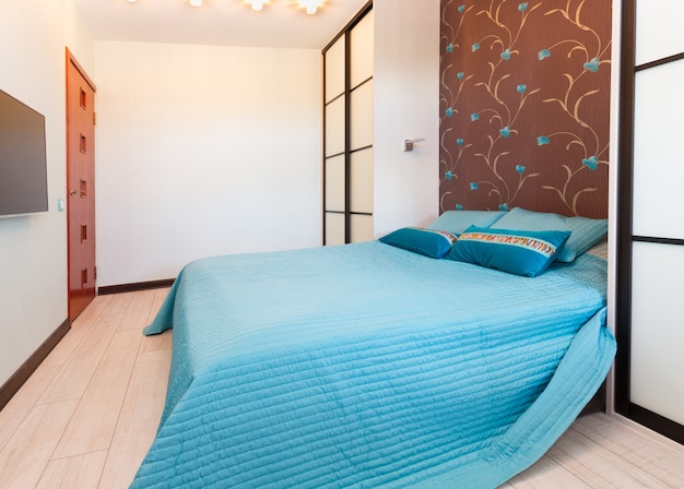 Modern empty bedroom with blue double bed