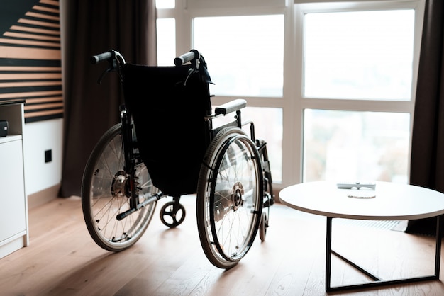 Supporto vuoto moderno della sedia a rotelle vicino alla finestra nella sala.