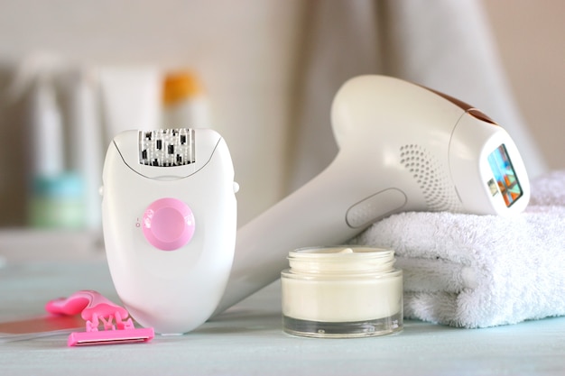 A modern epilator on the background of the bathroom interior