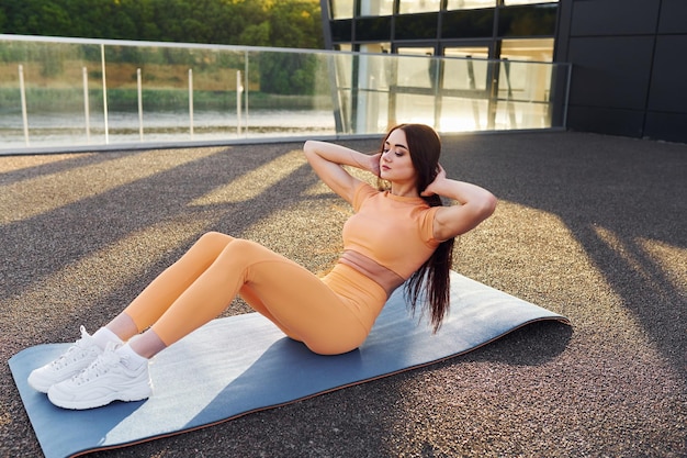 Modern exterior Young woman in sportswear have fitness session outdoors