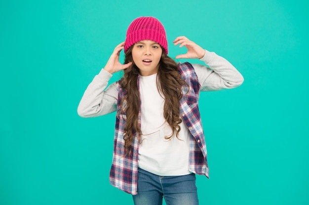 Modern fashion. How cool am I. Kids fashion. Girl cute child wear knitted hat. Little girl wearing winter hat. Comfy and cool. Girl long curly hair wear hat. Must have street style accessory trends.