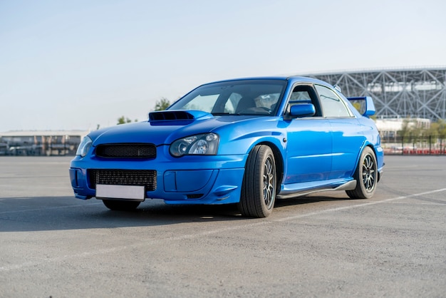 A modern fast race sport blue car on the track on summer practice day