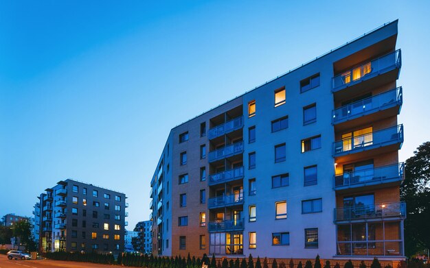 Modern flatgebouw architectuurconcept. Buiten woonhuis faciliteiten. 's Nachts