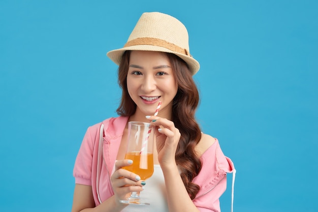 オレンジジュースを飲む現代の女の子。孤立した肖像画。