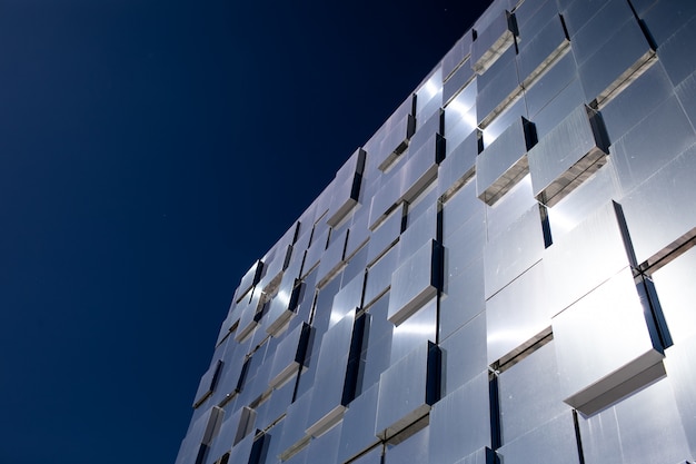 a modern glass building that reflects the sky. 