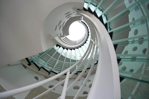 modern glass spiral staircase with metallic hand-rails.