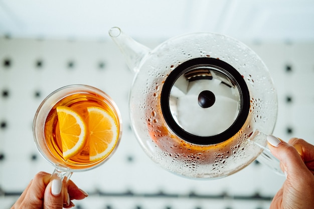 Современный стеклянный чайник и чашка чая с лимоном. Концепция чайной церемонии.