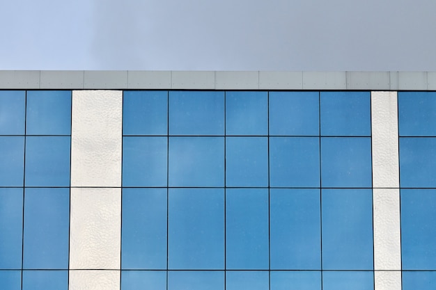 Modern glazen kantoorgebouw met blauwe hemelachtergrond. Bank financiële kantoorgebouw muur. Onroerend goed.