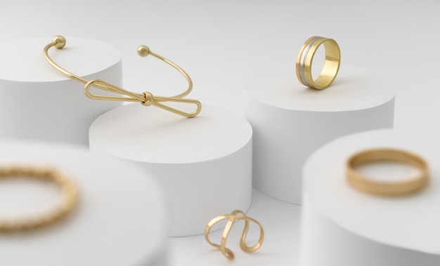 흰색 실린더 플랫폼에 현대 황금 활 모양 팔찌와 반지 컬렉션