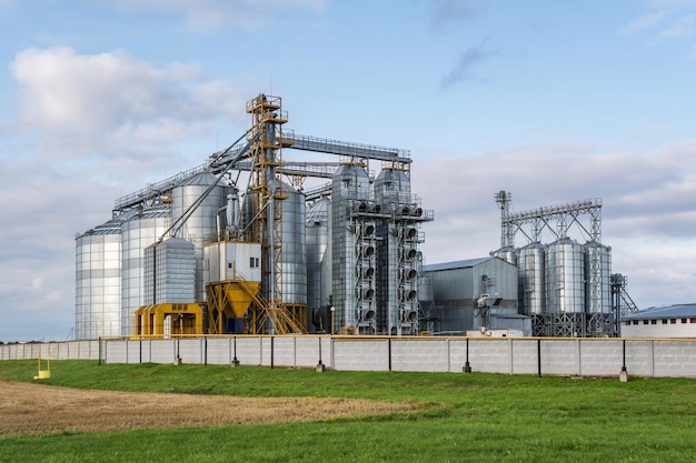 Modern granary elevator and seed cleaning line in silver silos on agroprocessing and manufacturing plant for storage and processing drying cleaning of agricultural products flour cereals and grain