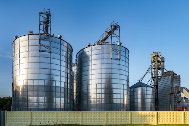 Modern Granary elevator with silver silos on agroprocessing and manufacturing plant for processing drying cleaning and storage of agricultural products flour cereals and grain