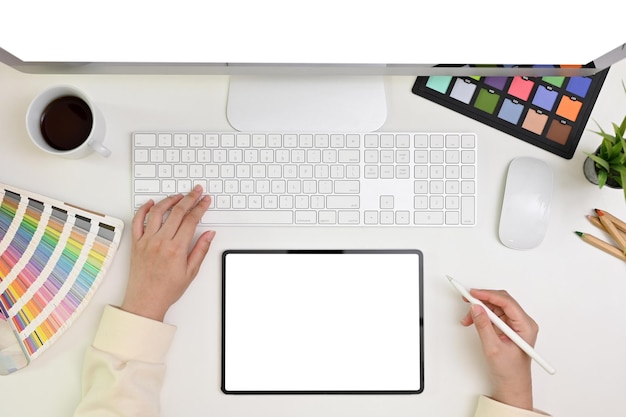 Modern graphic designer office desk top view A female graphic designer using tablet and computer