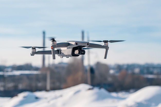 Modern gray drone in flight over the city New technology Blurred background