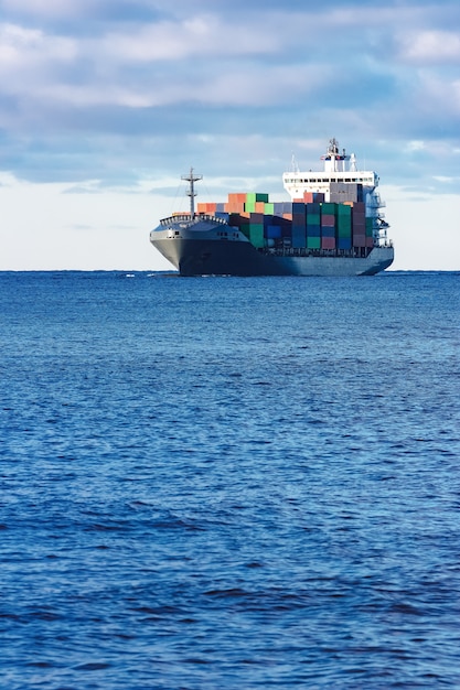 Modern grey container ship moving in still water