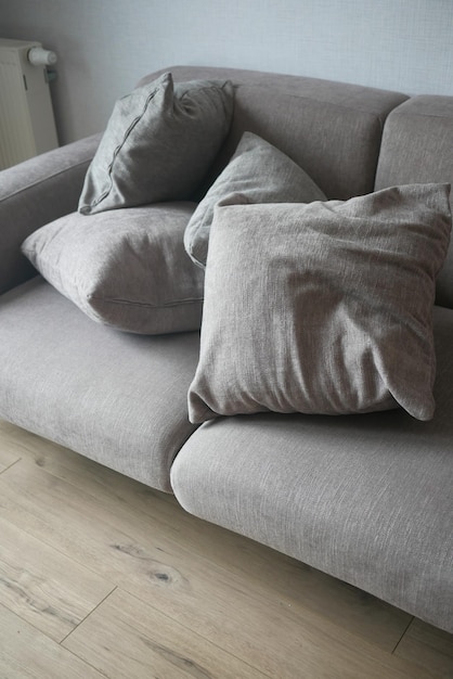 Modern grey sofa with pillows in living room at home