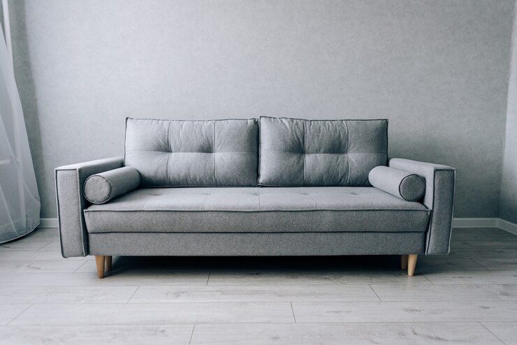 部屋に木製の脚が付いたモダンなグレーのソファ