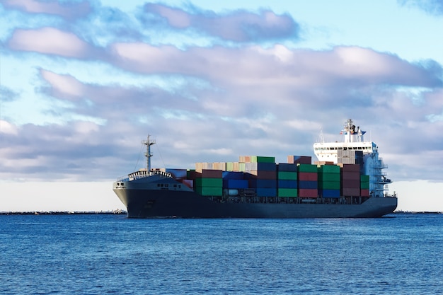 Modern grijs containerschip dat zich in stilstaand water beweegt