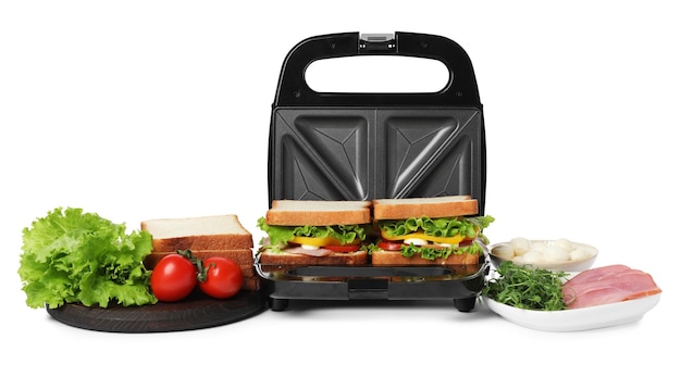 Modern grill maker with tasty sandwiches and ingredients on white background