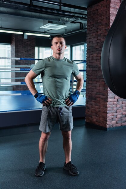 Modern gym. Strong famous muscle man standing in spacious modern gym while training hard