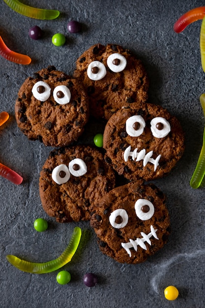 Photo modern halloween background. halloween cookies. funny monsters made of biscuits with chocolate on the table